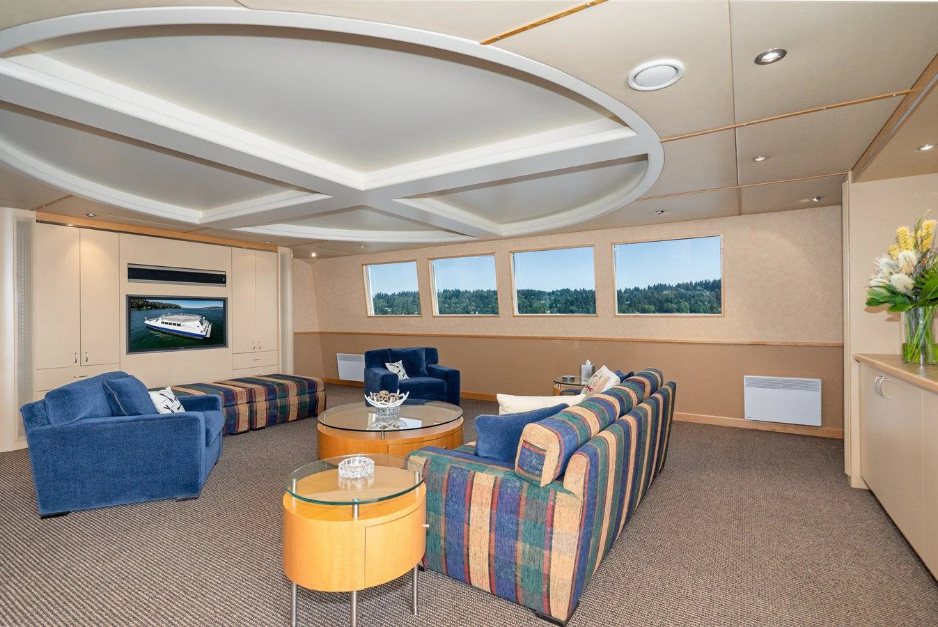 a living room with a blue couch and a table aboard DRAGONFLY Yacht for Sale