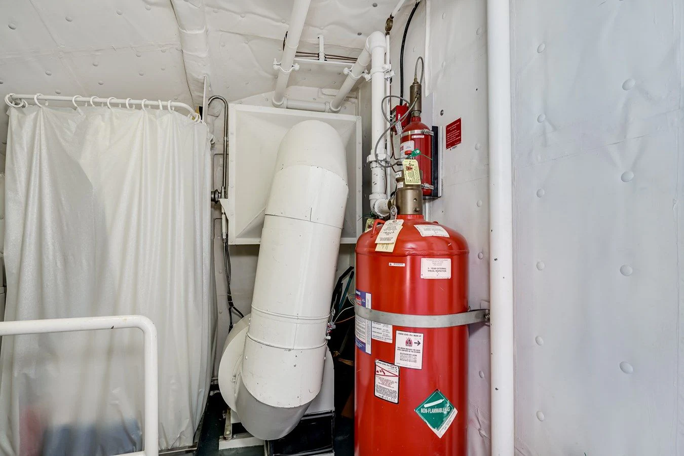a red and white canister in a room with white curtains aboard DRAGONFLY Yacht for Sale