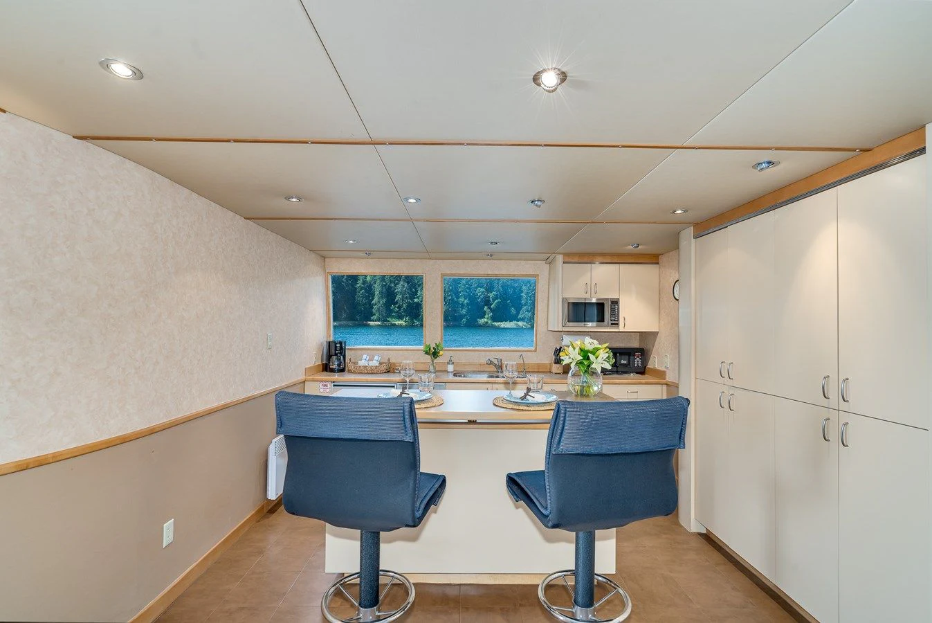 a kitchen with a blue chair aboard DRAGONFLY Yacht for Sale