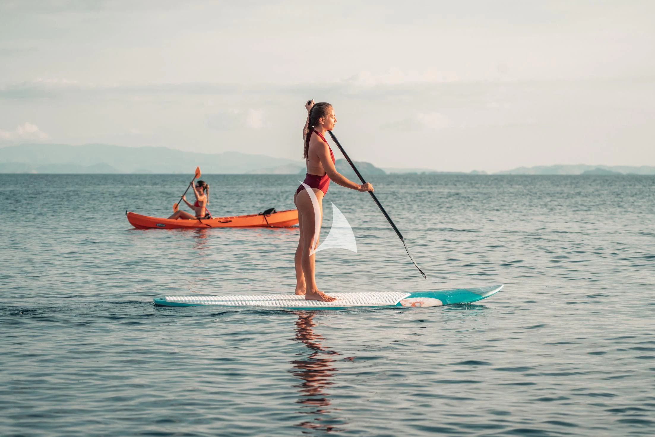 a man in a bikini on a surfboard with a paddle aboard THE MAJ OCEANIC Yacht for Charter