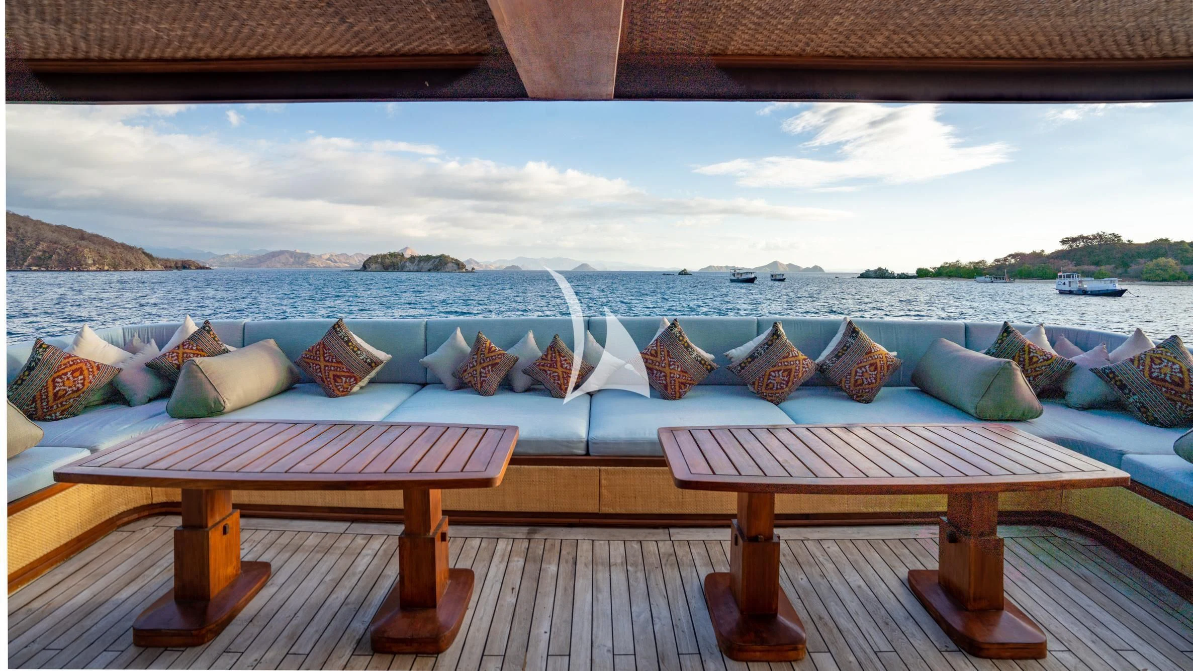 a table and a couch on a balcony overlooking a city aboard THE MAJ OCEANIC Yacht for Charter