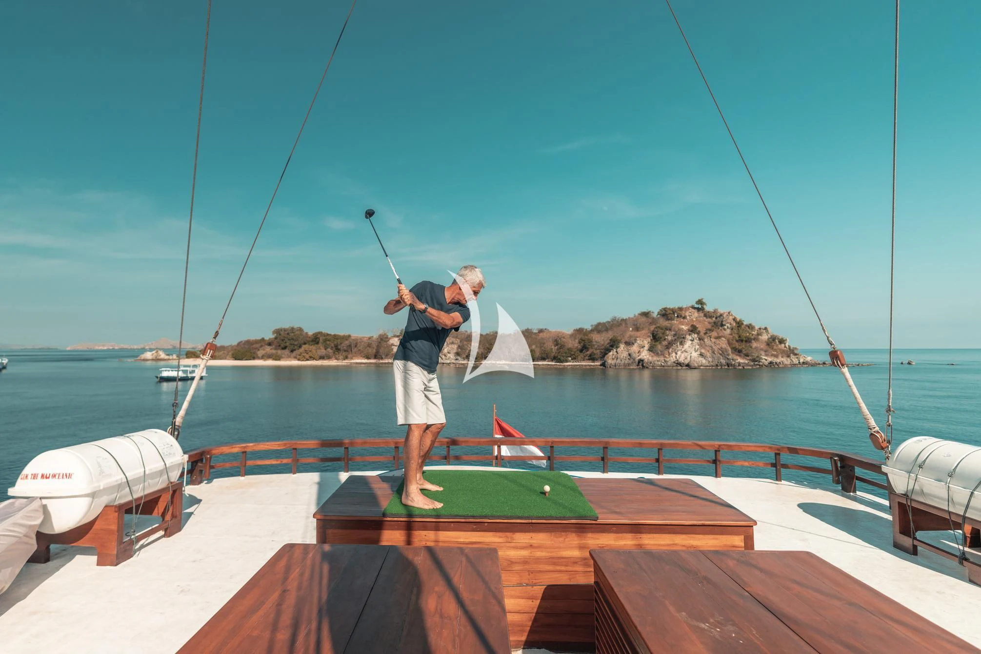 a person standing on a boat holding a fishing pole aboard THE MAJ OCEANIC Yacht for Charter