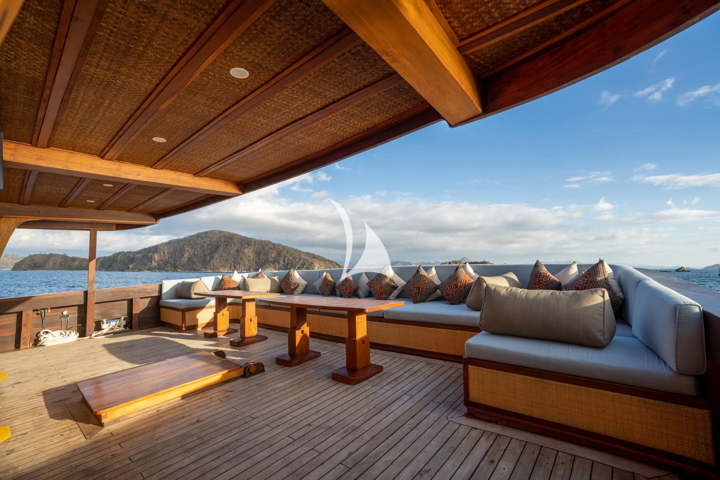 a patio with a view of the ocean and mountains aboard THE MAJ OCEANIC Yacht for Charter