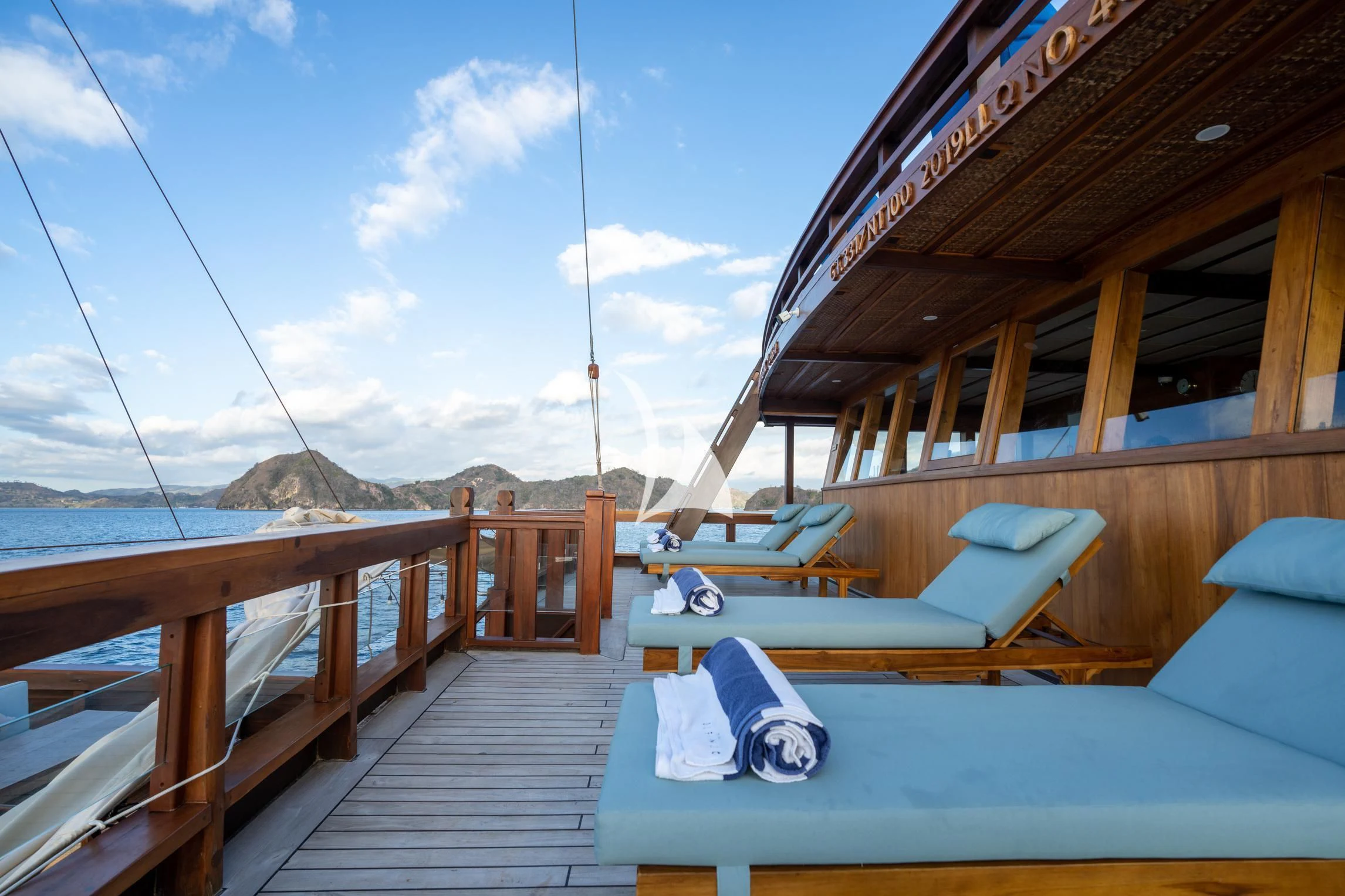 a deck with a boat and a hammock on it aboard THE MAJ OCEANIC Yacht for Charter