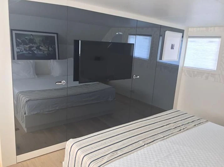a room with a bed and a television aboard VIKA Yacht for Sale