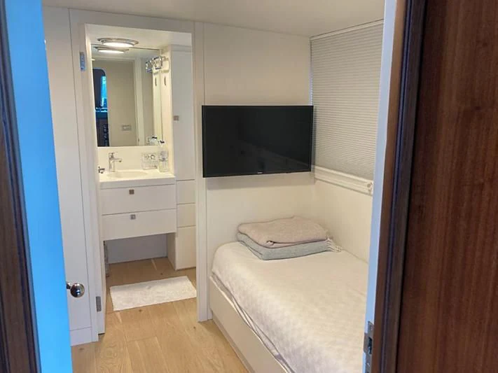 a bathroom with a bed and a television aboard VIKA Yacht for Sale