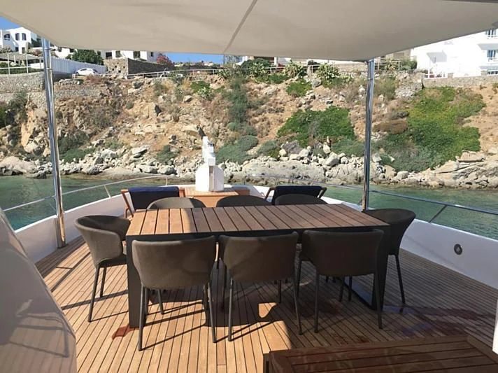 a table with chairs and a view of a city aboard VIKA Yacht for Sale