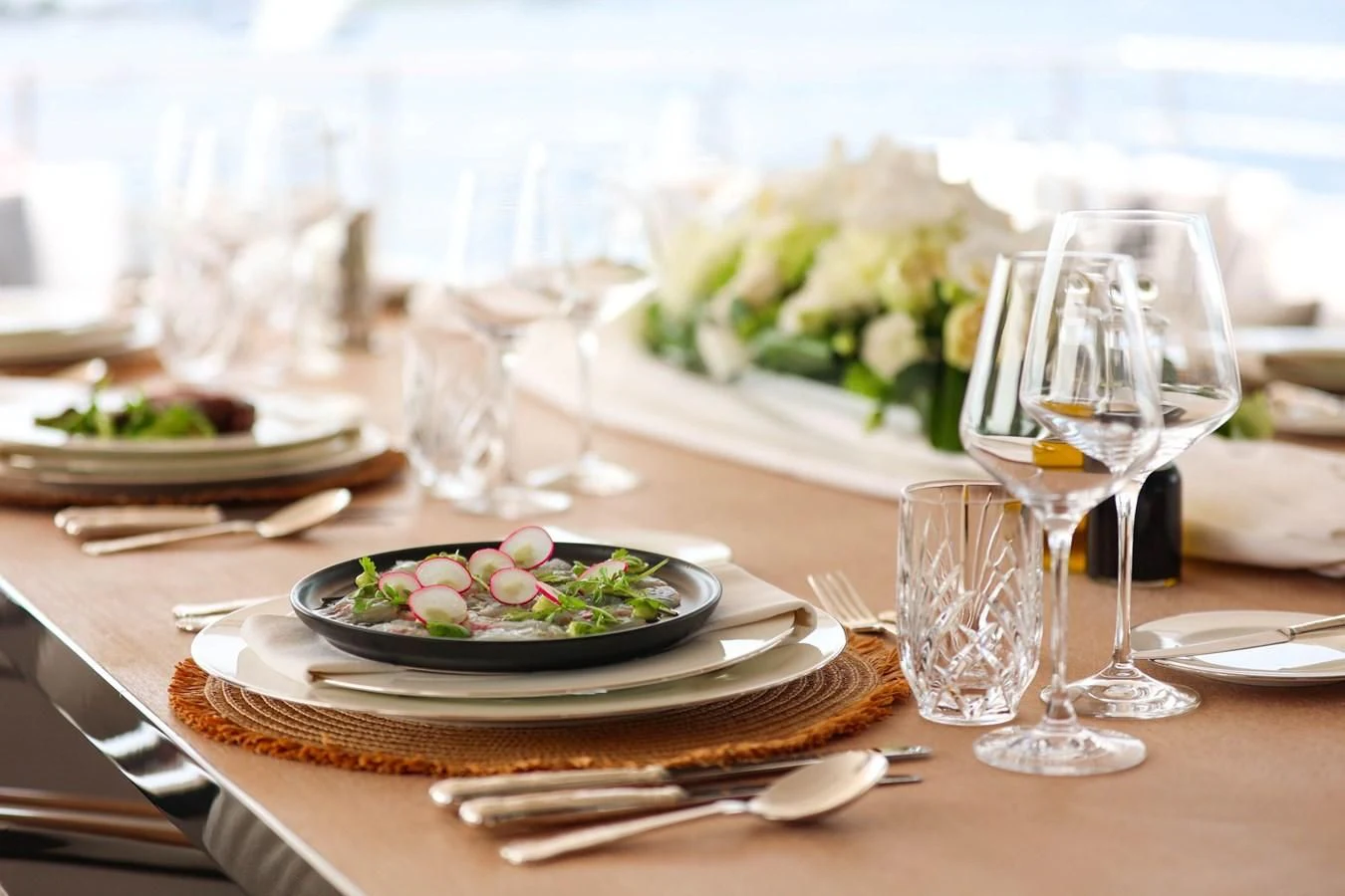 a table with plates and glasses of wine aboard MEDIALLY Yacht for Sale