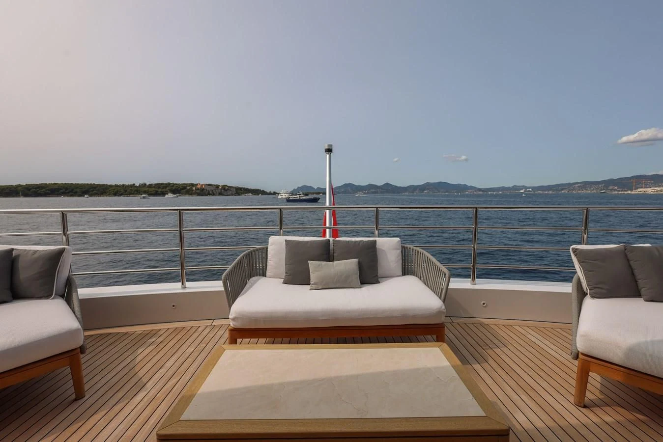 a large white sofa on a deck overlooking a body of water aboard MEDIALLY Yacht for Sale