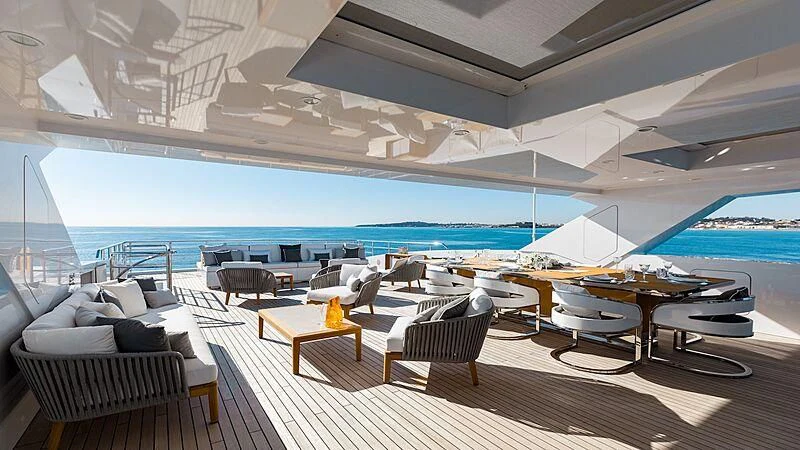 a room with a table chairs and a pool aboard MEDIALLY Yacht for Sale