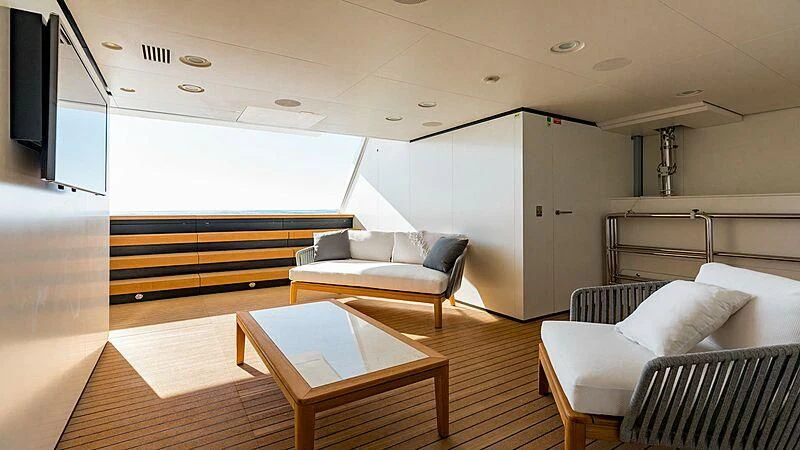 a living room with a table and couches aboard MEDIALLY Yacht for Sale