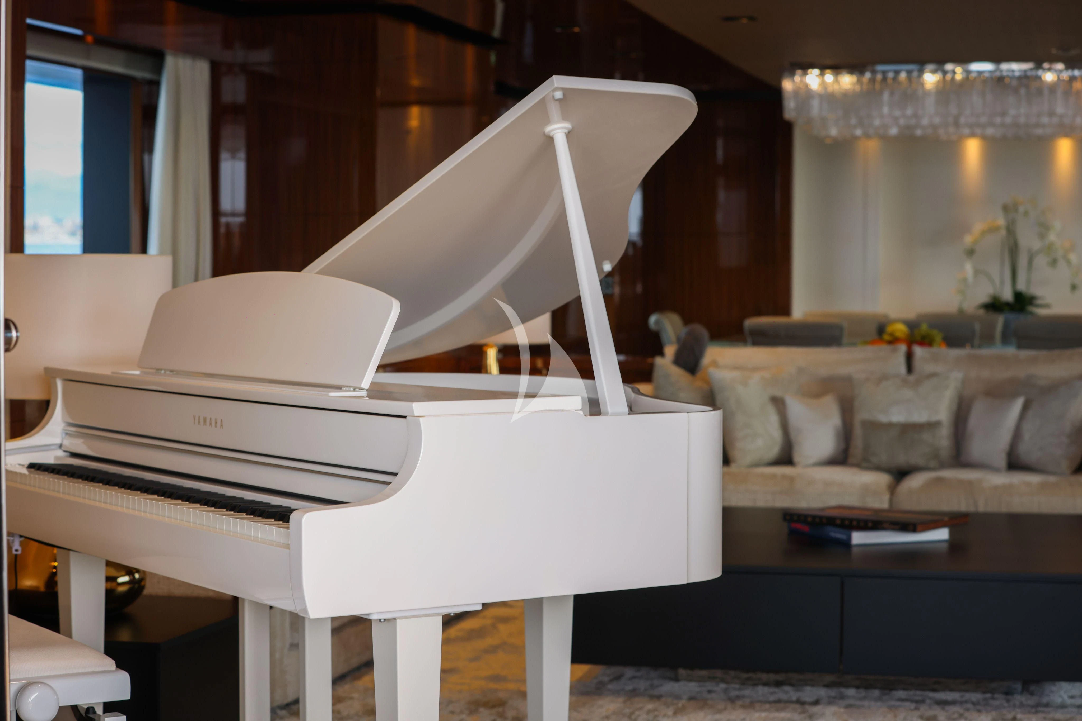 a white piano in a living room aboard MEDIALLY Yacht for Sale