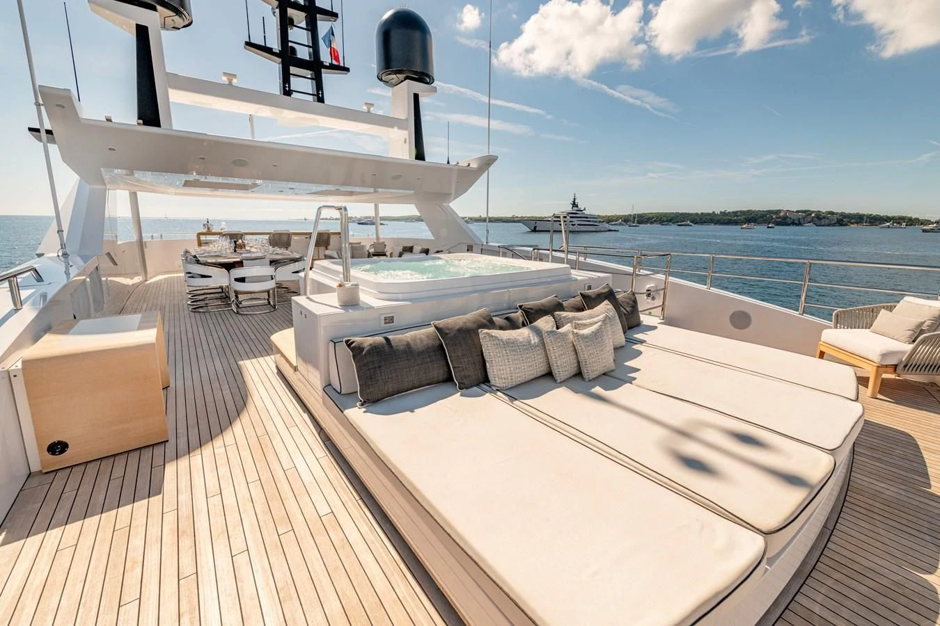 a deck with a large white boat on it and a deck with chairs and a table and a aboard MEDIALLY Yacht for Sale