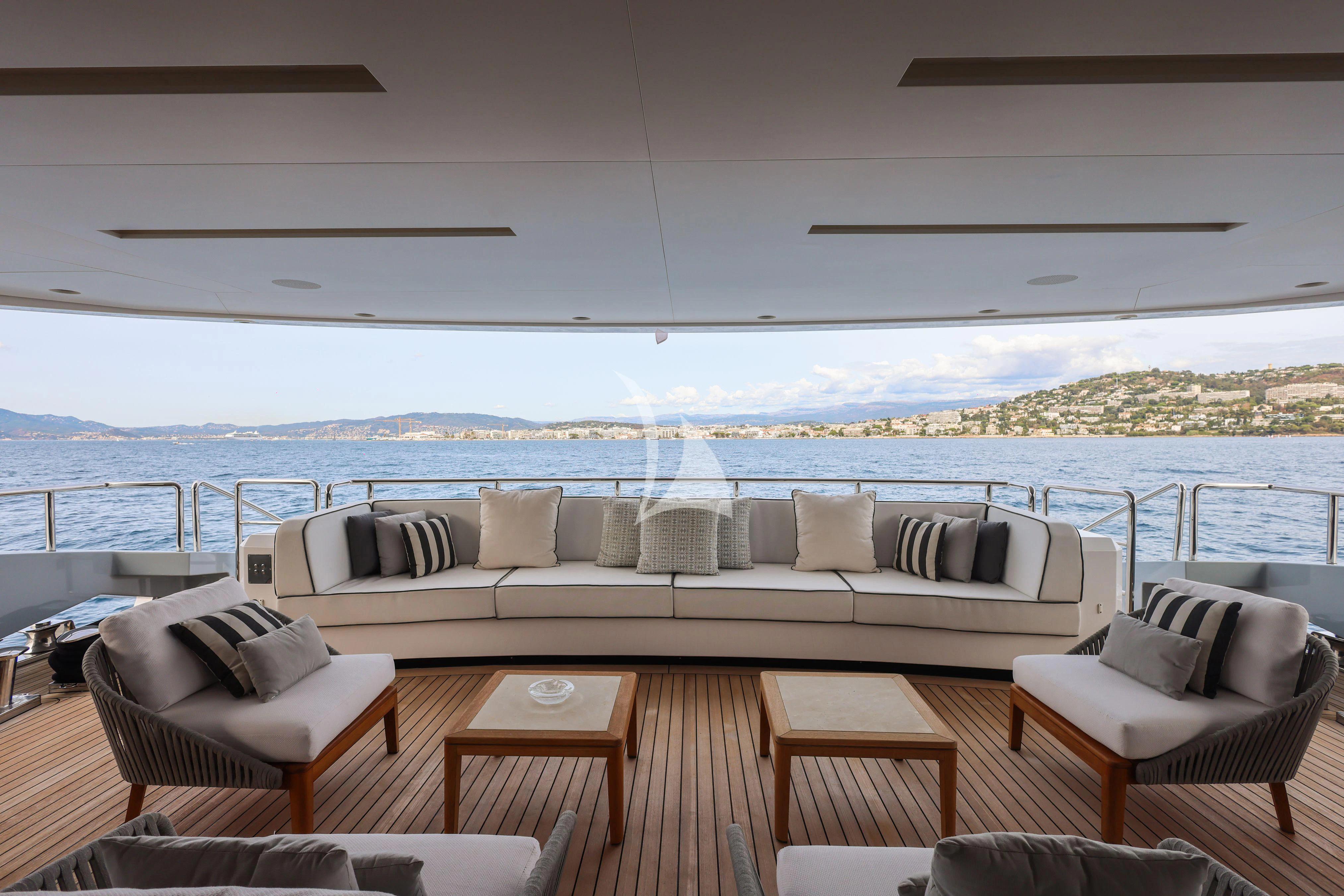 a living room with a large body of water in the background aboard MEDIALLY Yacht for Sale