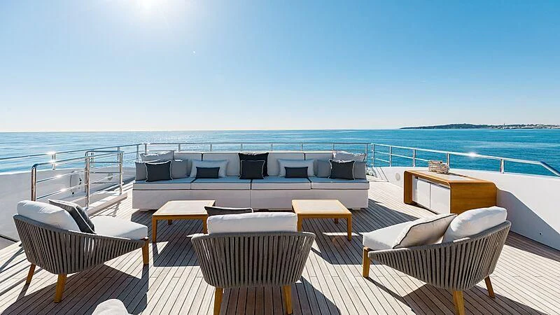 a deck with chairs and a body of water in the background aboard MEDIALLY Yacht for Sale