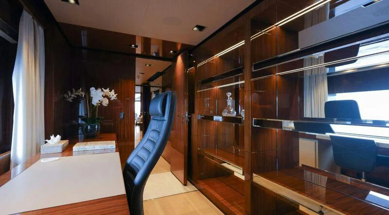 a room with a wood shelf and a chair and a table aboard MEDIALLY Yacht for Sale