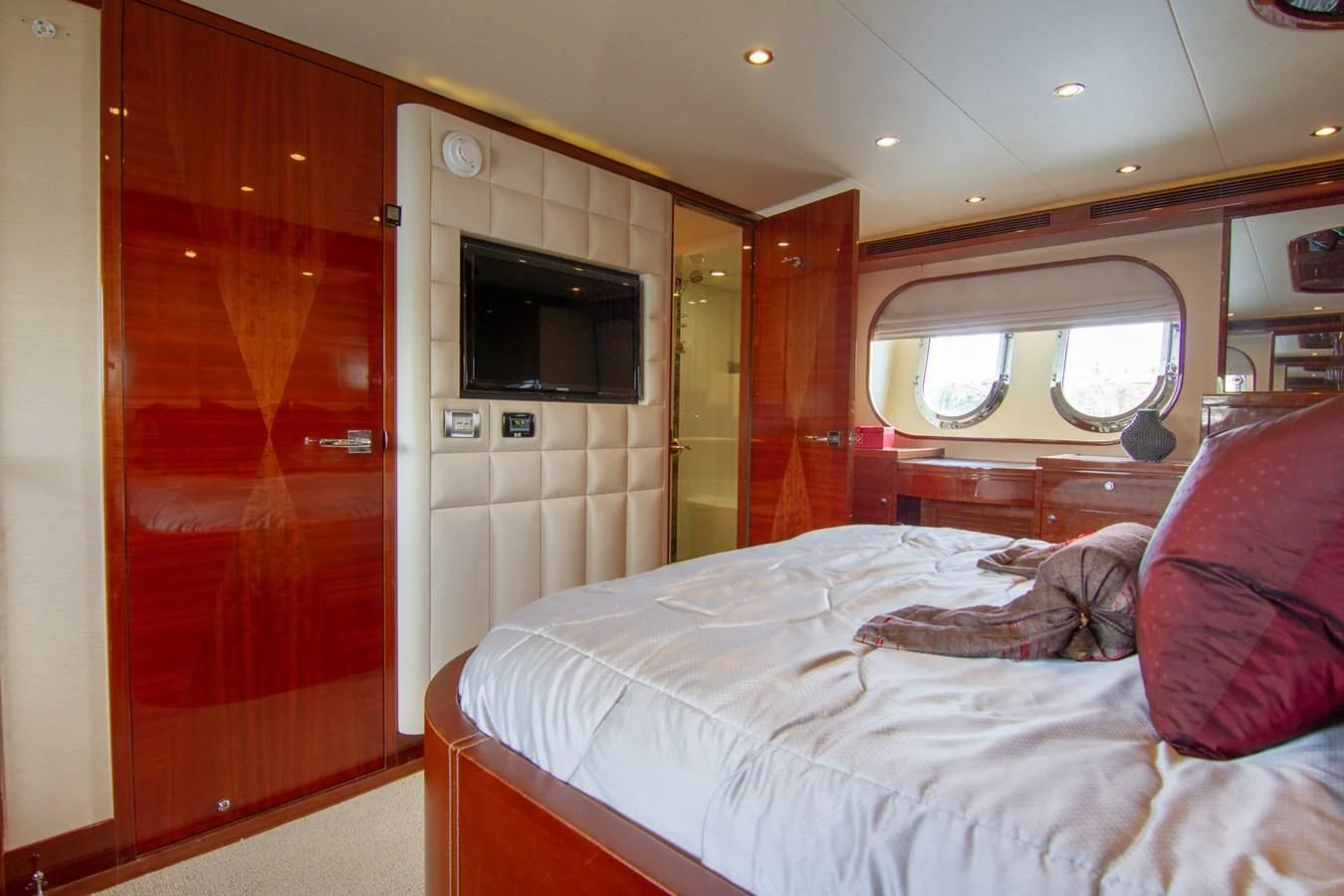 a bedroom with a bed and a television on the wall aboard BRAVO Yacht for Sale