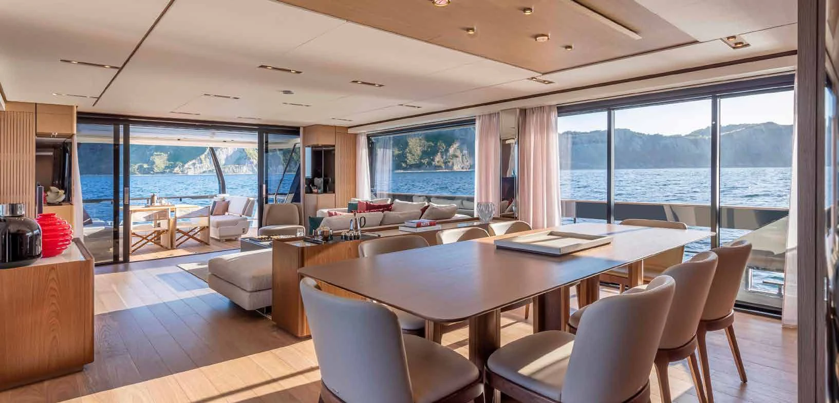 a large room with a table and chairs and a large window aboard SPICA Yacht for Sale