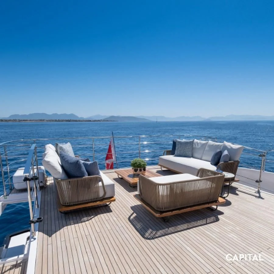 a deck with chairs and a body of water in the background aboard SPICA Yacht for Sale