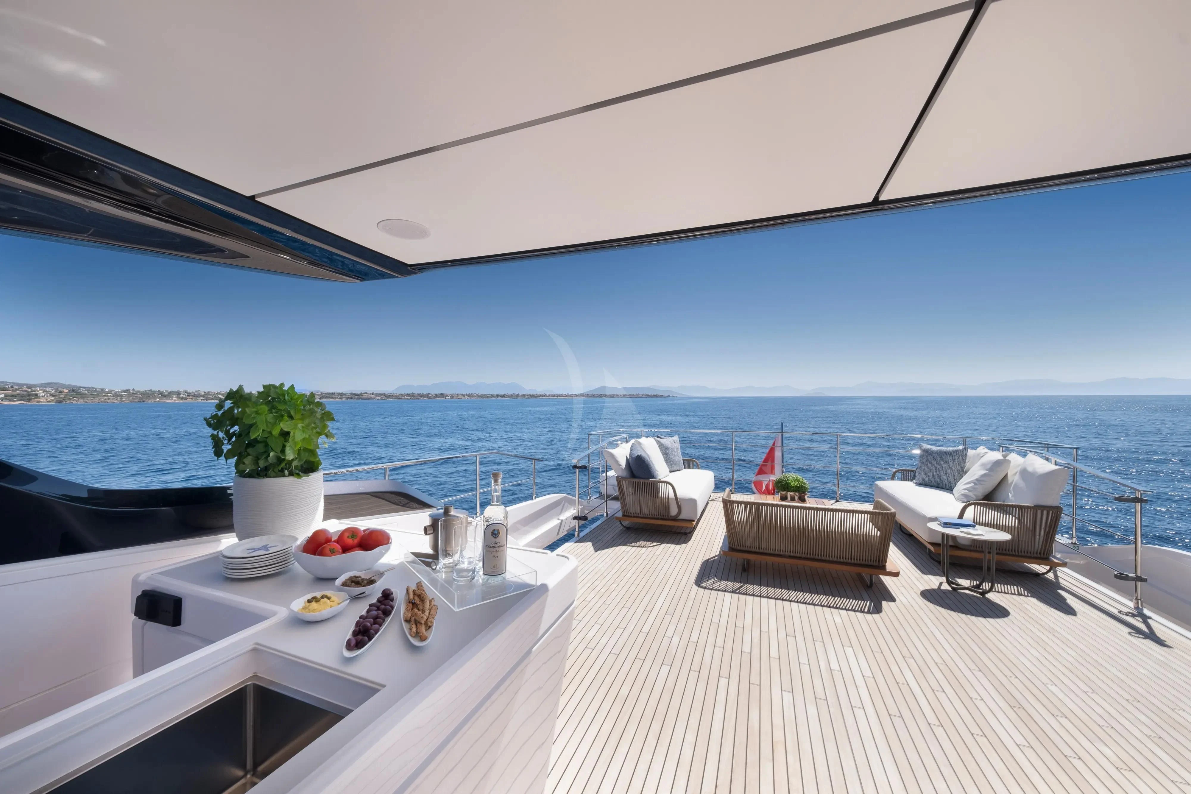 a room with a table chairs and a view of the ocean aboard SPICA Yacht for Sale
