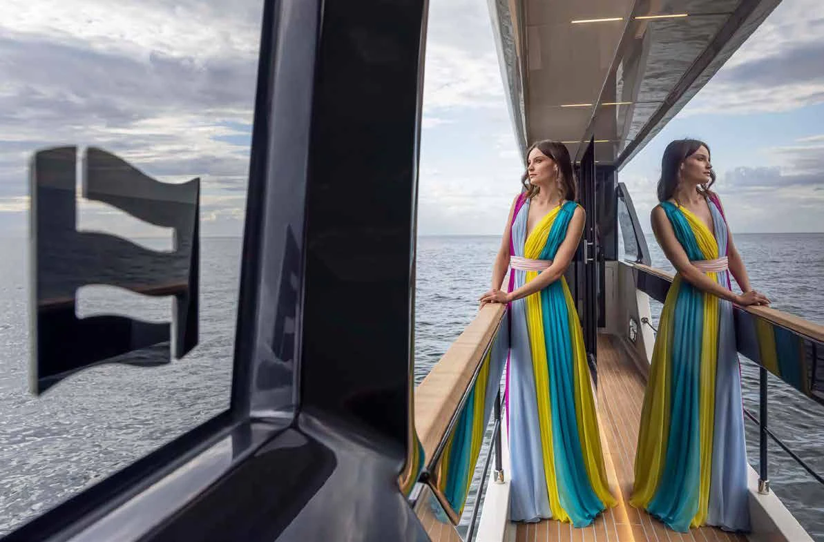 a person in a colorful dress standing on a balcony aboard SPICA Yacht for Sale