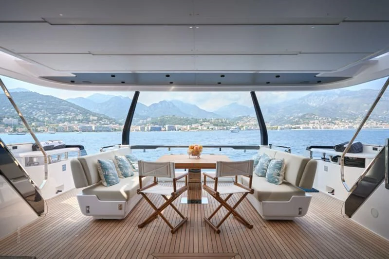 a room with a table chairs and a view of a city aboard SPICA Yacht for Sale