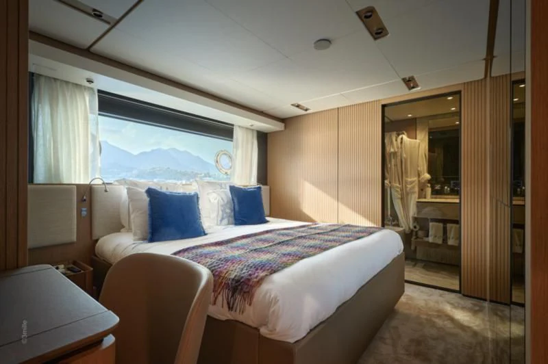 a room with a bed and a window aboard SPICA Yacht for Sale