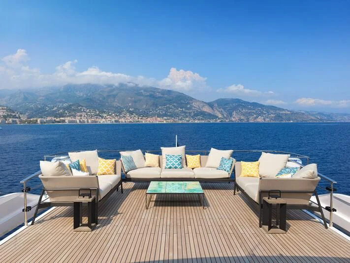 a deck with a view of a city and mountains in the background aboard SPICA Yacht for Sale