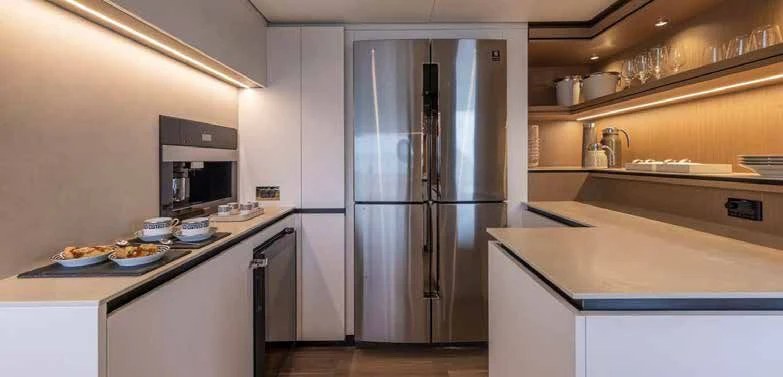 a kitchen with a stainless steel refrigerator aboard SPICA Yacht for Sale