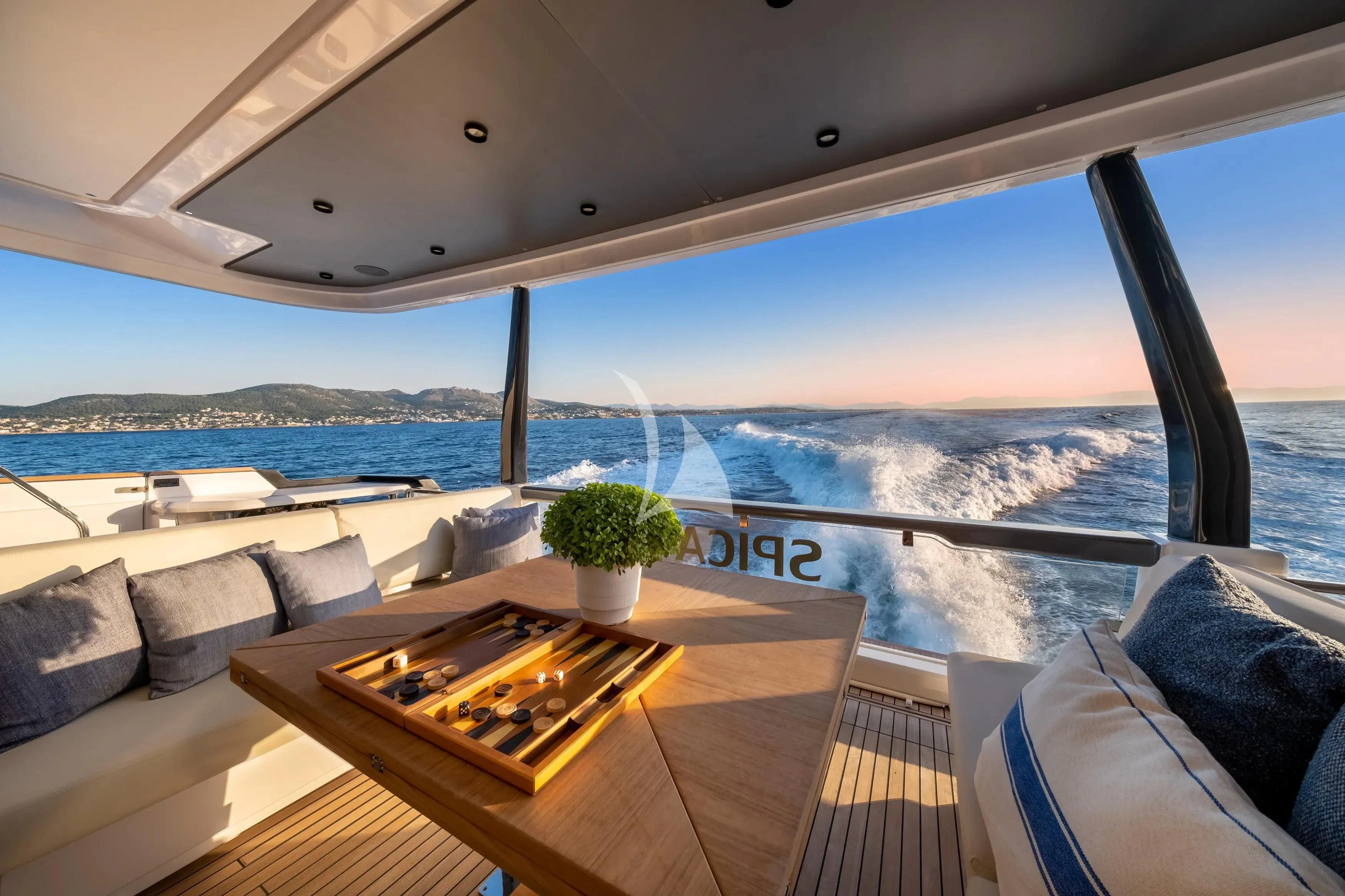a table on a deck overlooking a body of water aboard SPICA Yacht for Sale