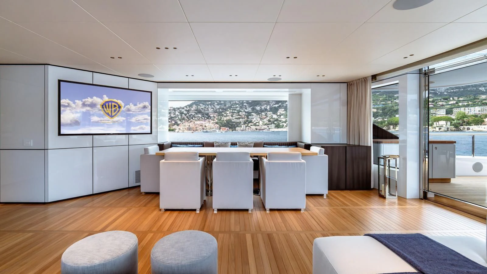 a room with a large window and a table with chairs aboard TOSUN Yacht for Sale