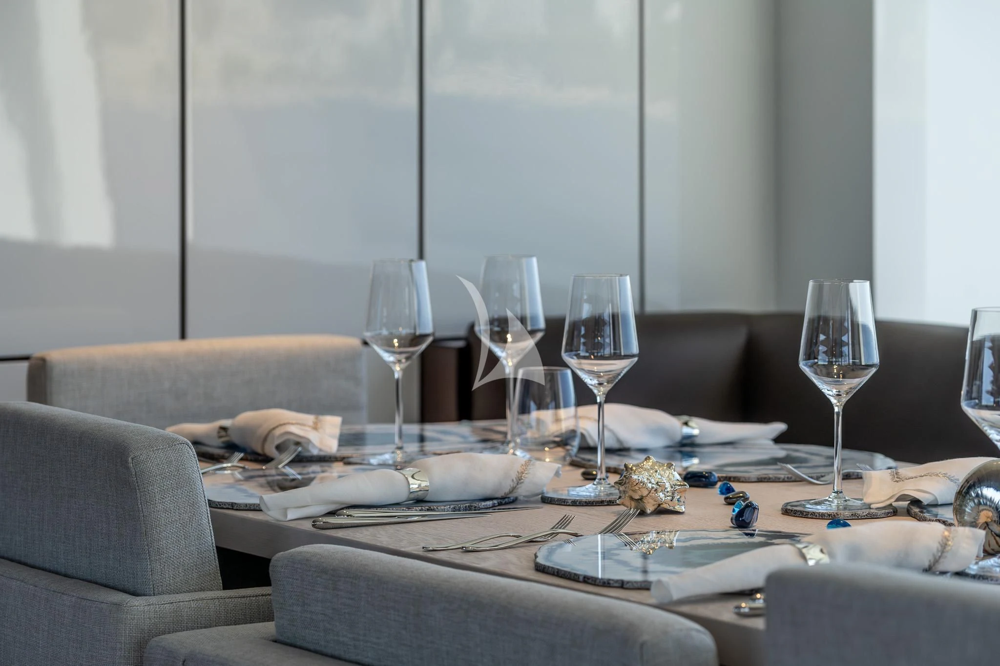 a table with wine glasses and plates aboard TOSUN Yacht for Sale