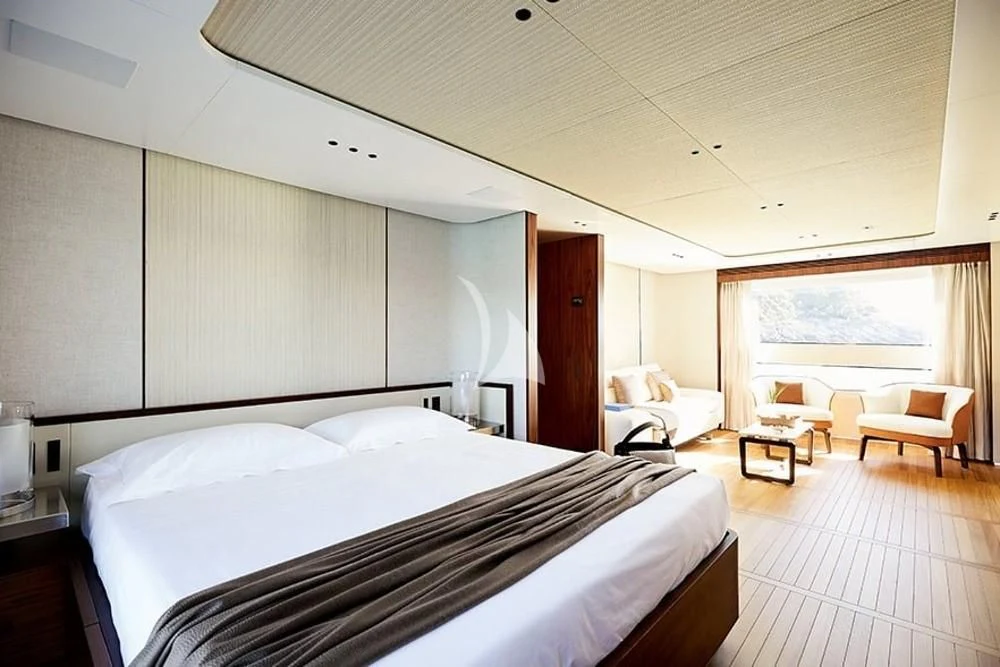 a room with a bed and a chair aboard TOSUN Yacht for Sale