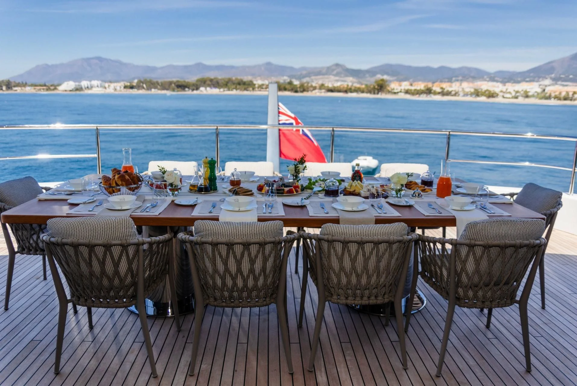 a table set for a meal on a deck overlooking the ocean aboard TOSUN Yacht for Sale
