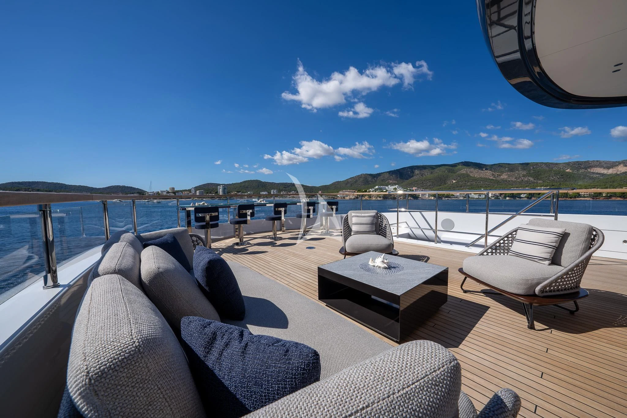 a deck with chairs and a table on it aboard TOSUN Yacht for Sale
