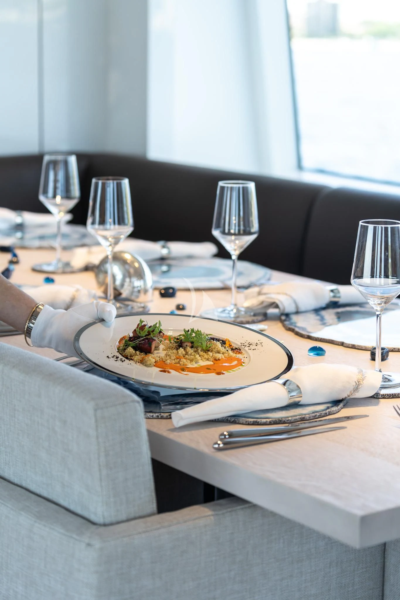 a plate of food and wine on a table aboard TOSUN Yacht for Sale