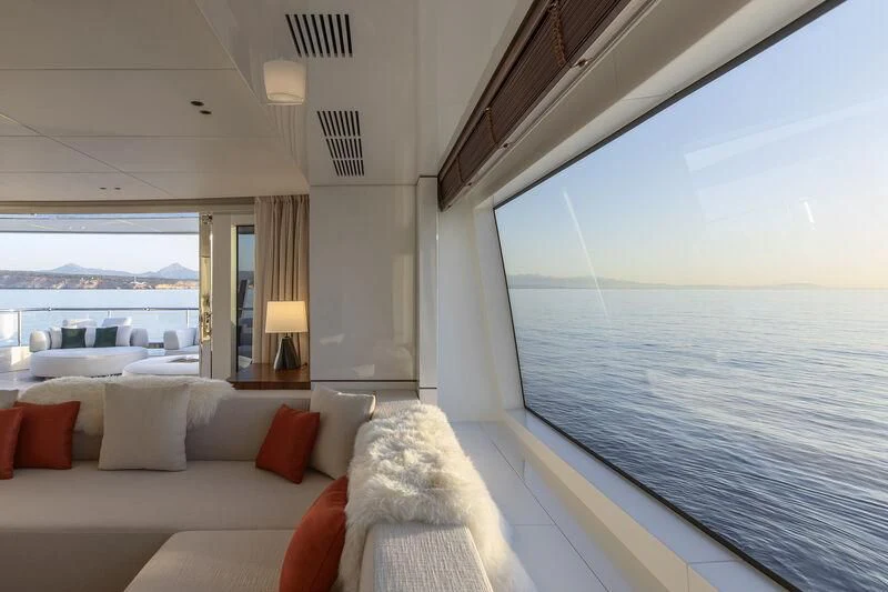 a large white room with a couch and a large blue ocean aboard TOSUN Yacht for Sale