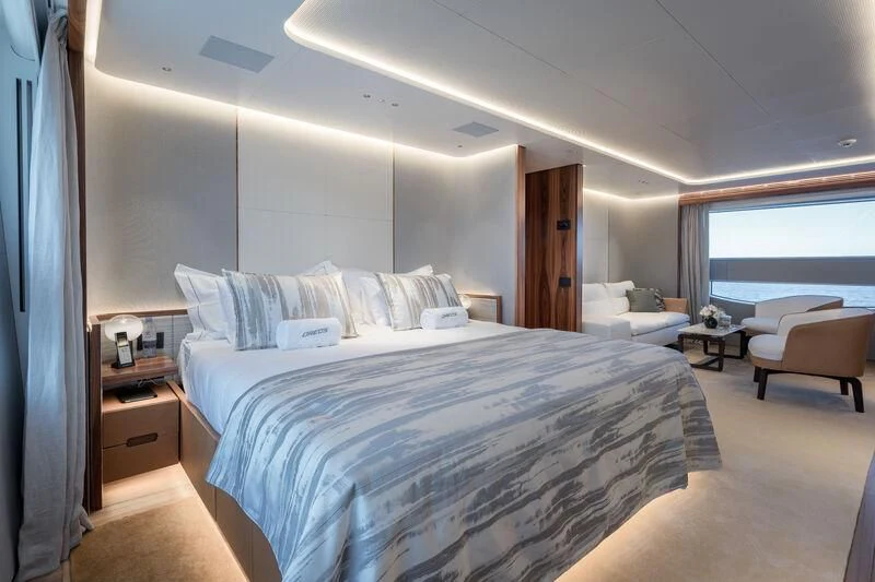 a bedroom with a bed and a chair aboard TOSUN Yacht for Sale