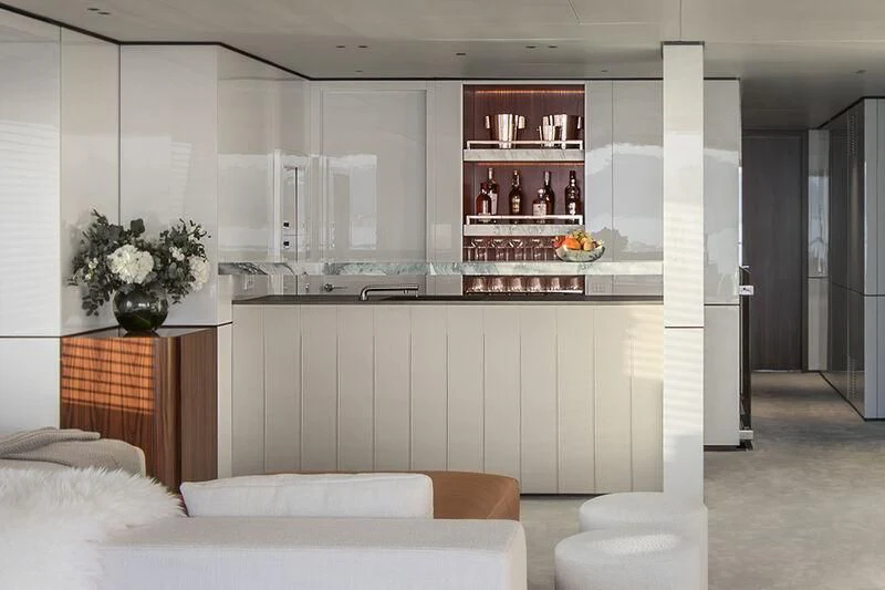 a room with a white couch and a shelf with bottles on it aboard TOSUN Yacht for Sale