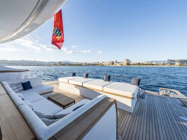 a deck with chairs and a flag aboard TOSUN Yacht for Sale