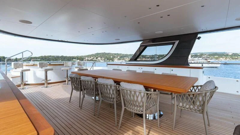 a deck with chairs and tables on it aboard TOSUN Yacht for Sale