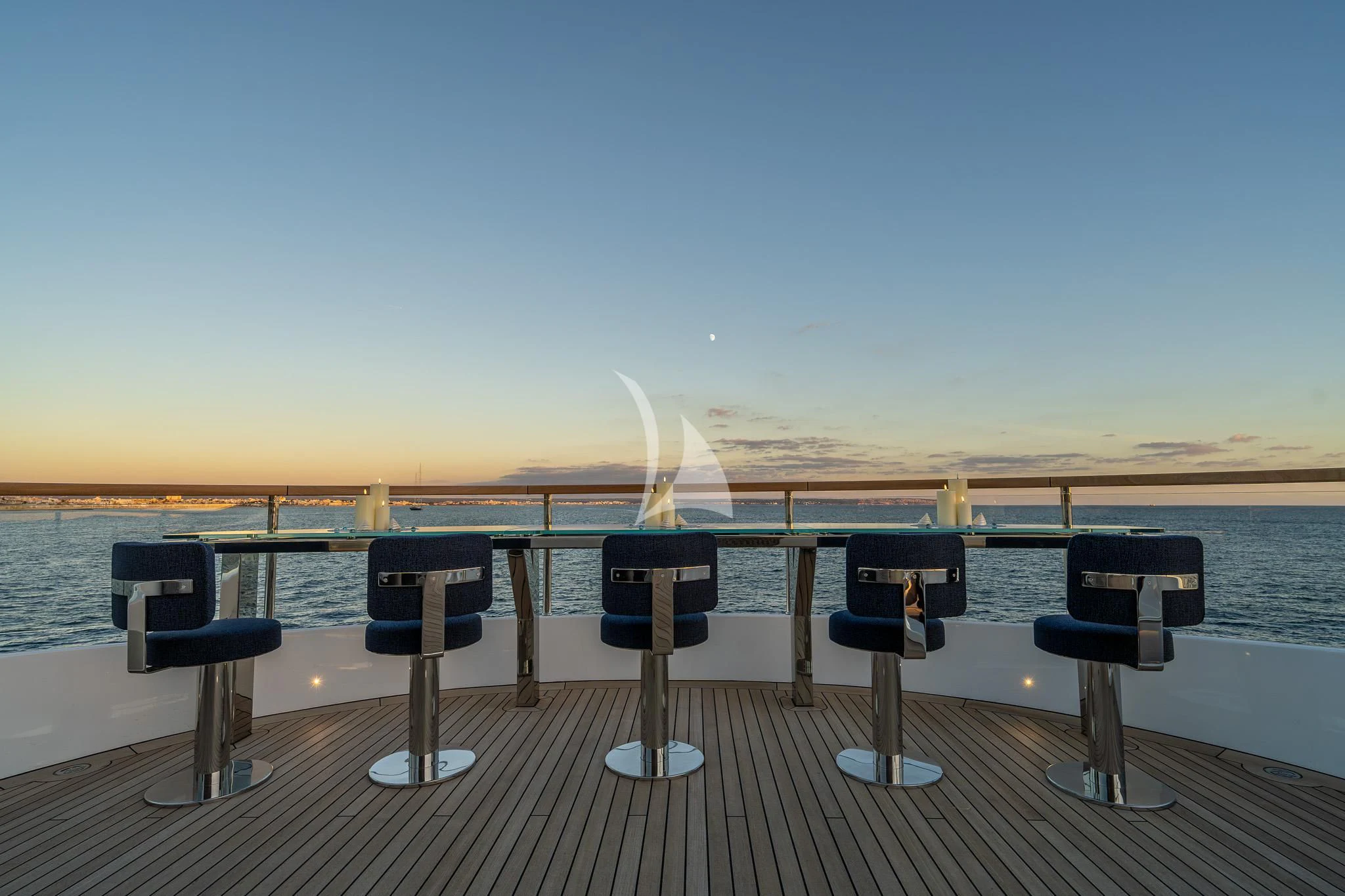 a deck with chairs and tables on it by the water aboard TOSUN Yacht for Sale