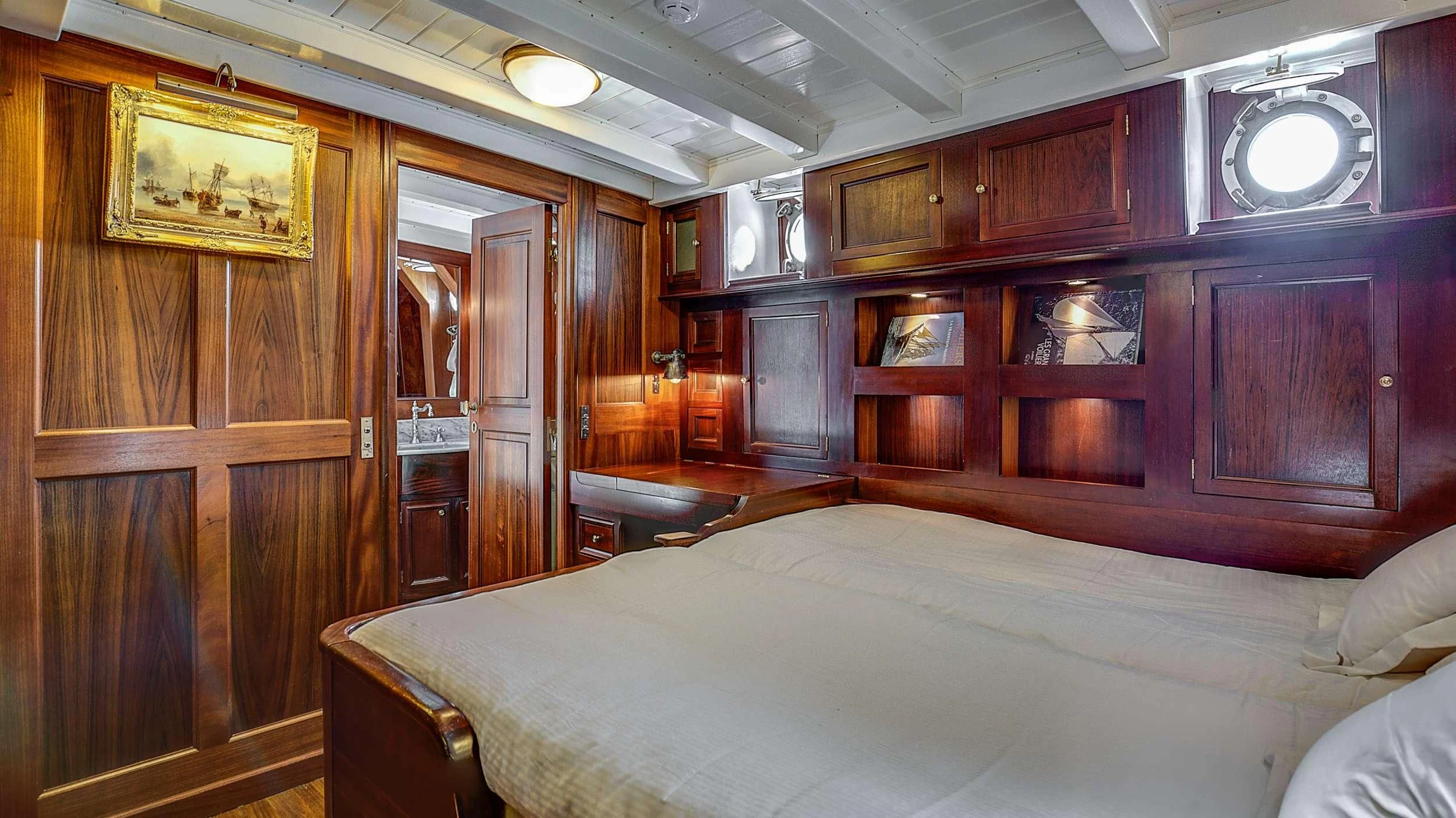 a room with a bed and a mirror aboard TRINAKRIA Yacht for Charter