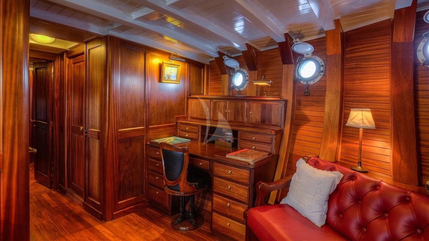 a living room with a couch and a piano aboard TRINAKRIA Yacht for Charter