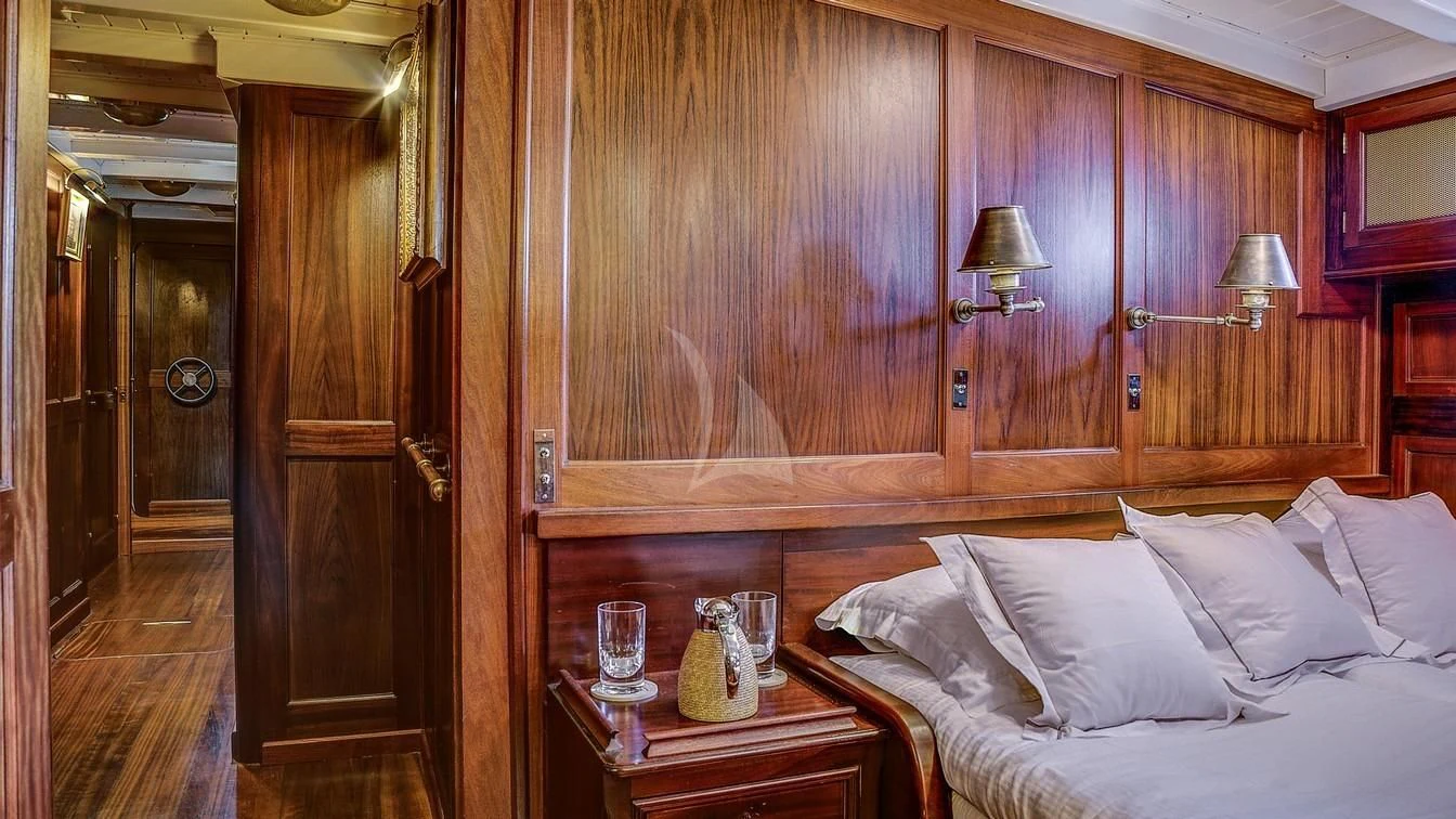 a bed and a table in a room aboard TRINAKRIA Yacht for Charter