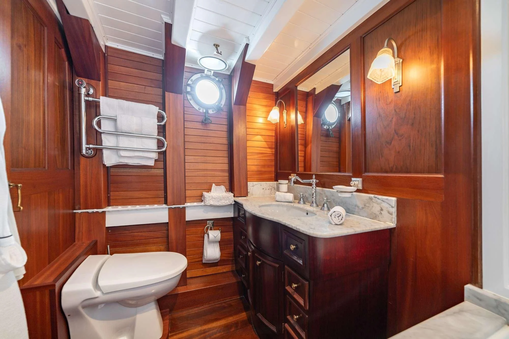 a bathroom with a sink toilet and a mirror aboard TRINAKRIA Yacht for Charter