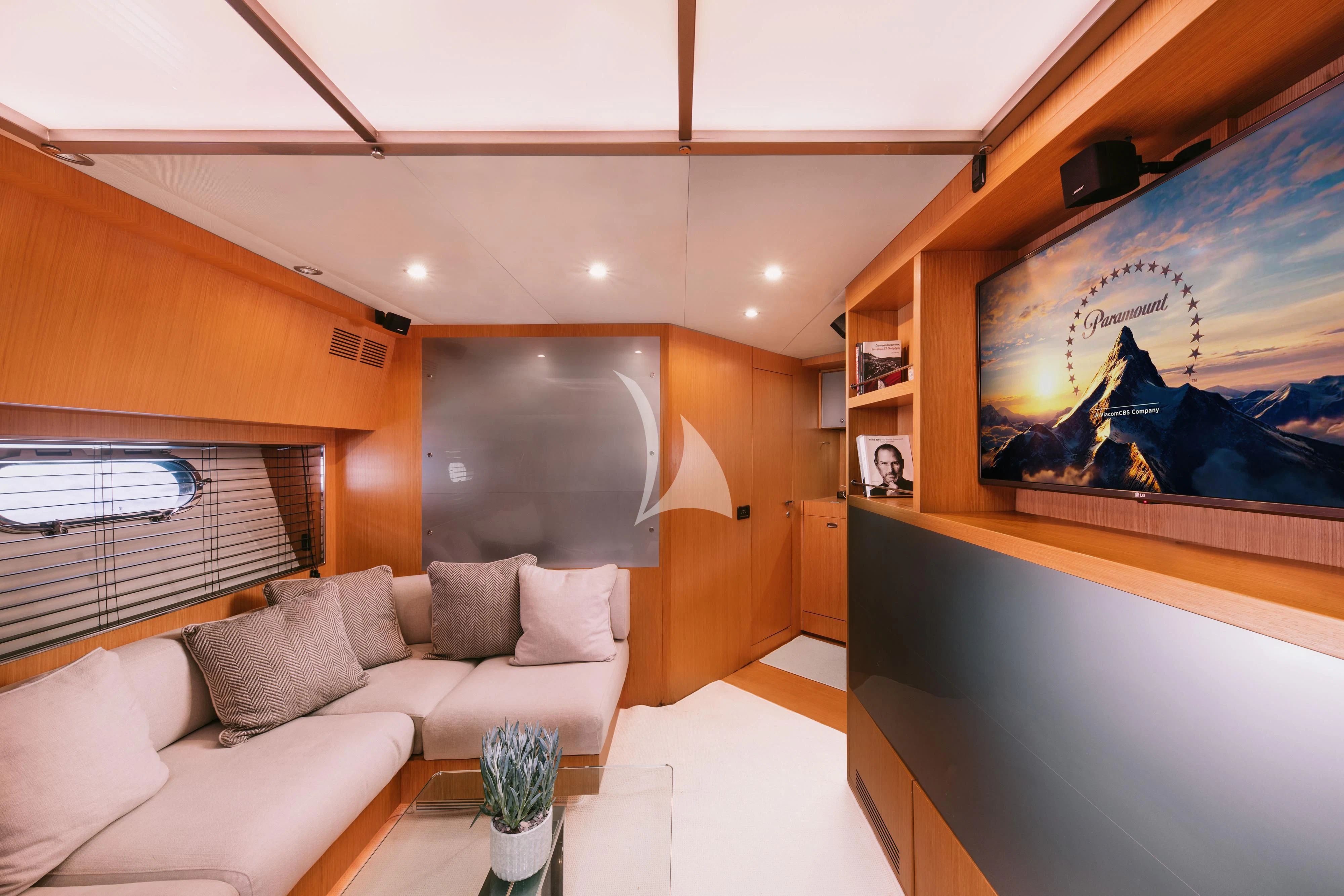 a room with a couch and a television aboard WHO CARES Yacht for Sale