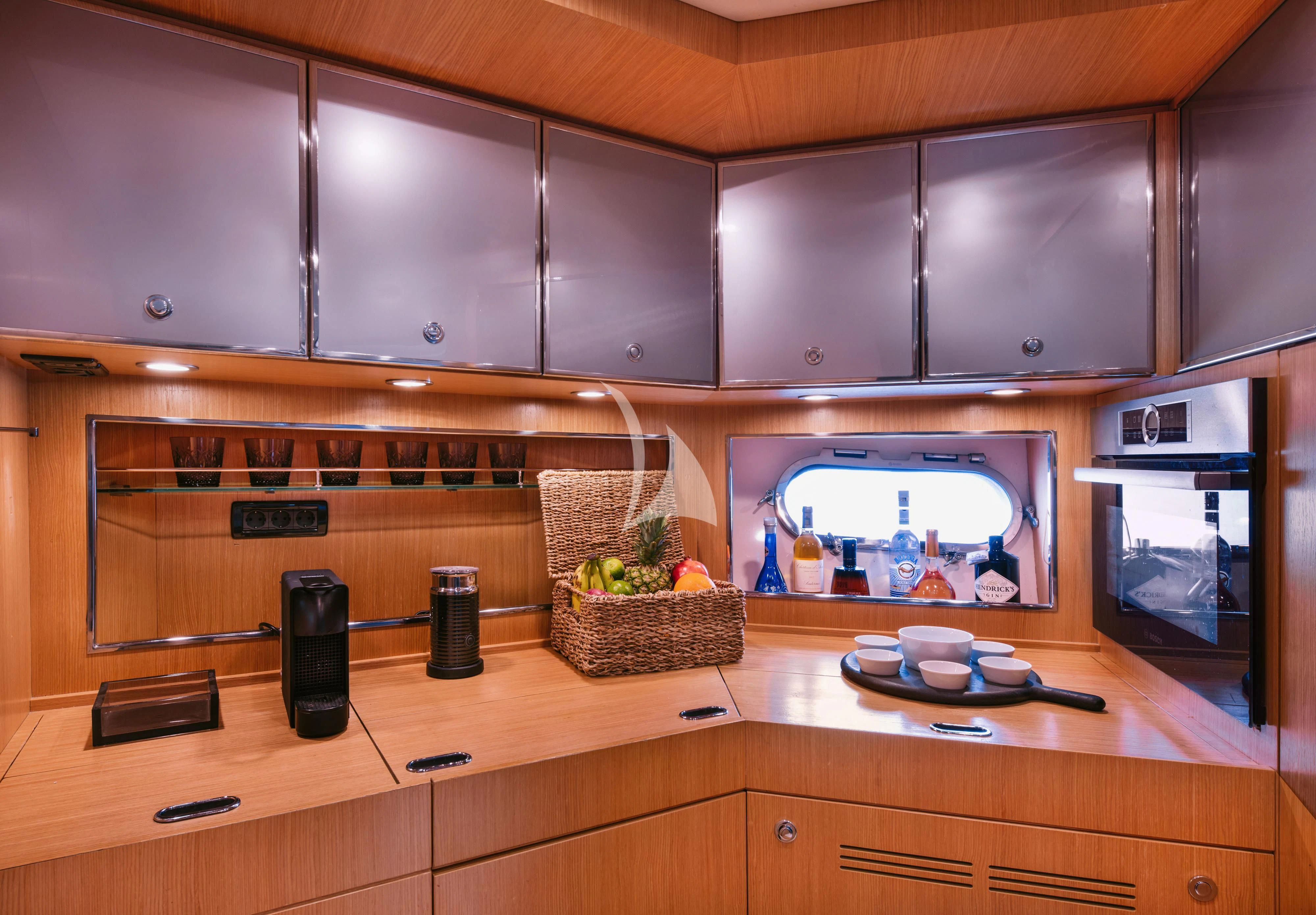 a kitchen with a microwave oven and a basket of food aboard WHO CARES Yacht for Sale