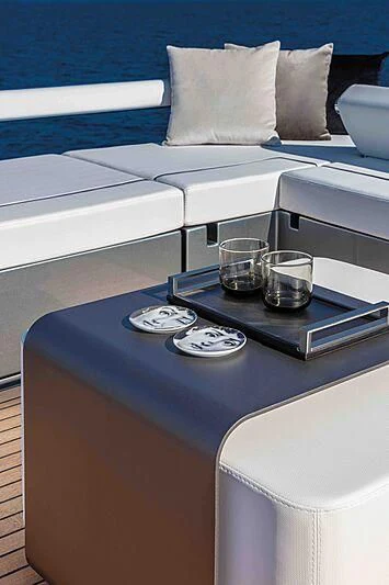 a coffee table with a glass cup on top aboard GREY SHARK Yacht for Sale