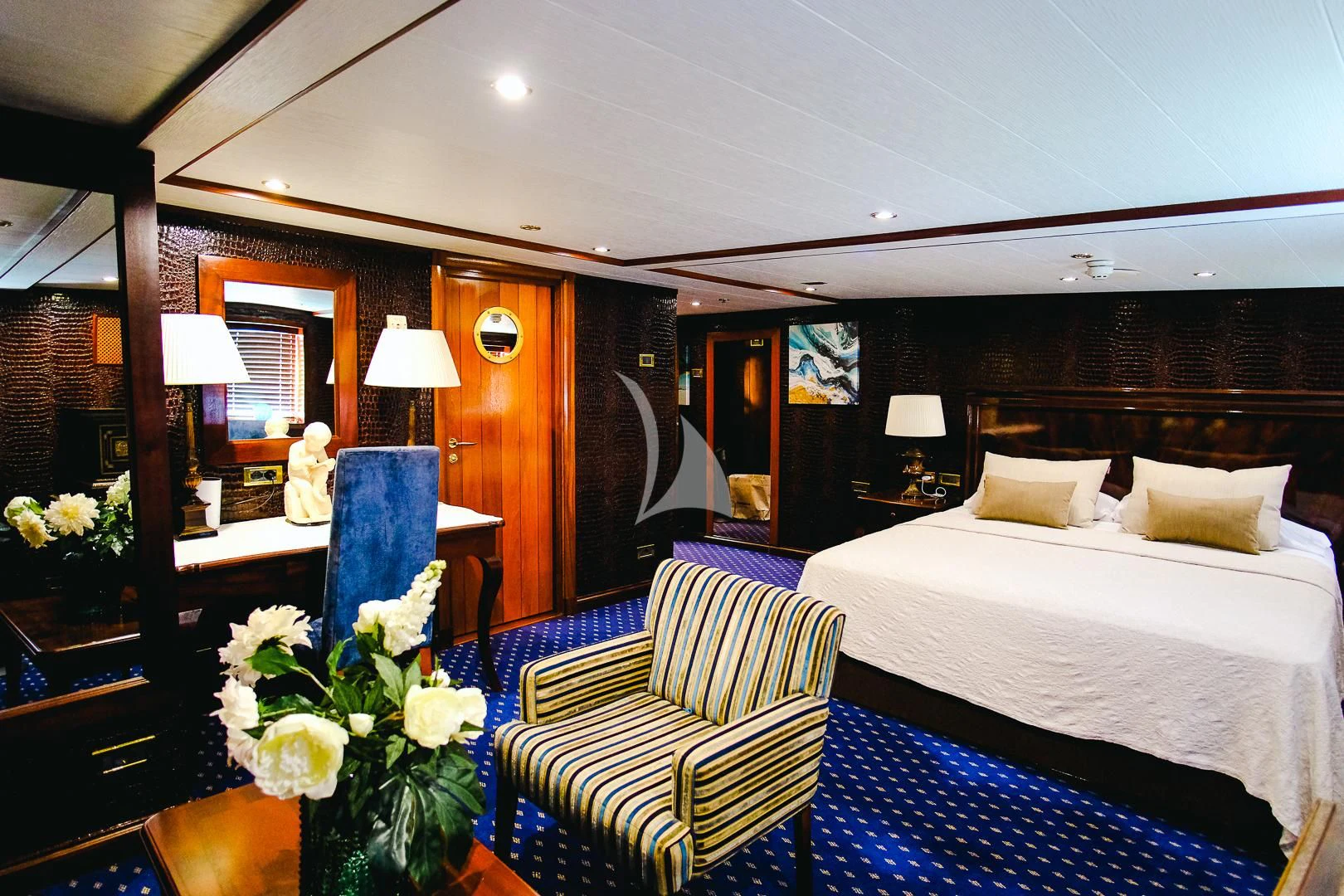 a hotel room with a bed and flowers aboard HARMONY II Yacht for Sale